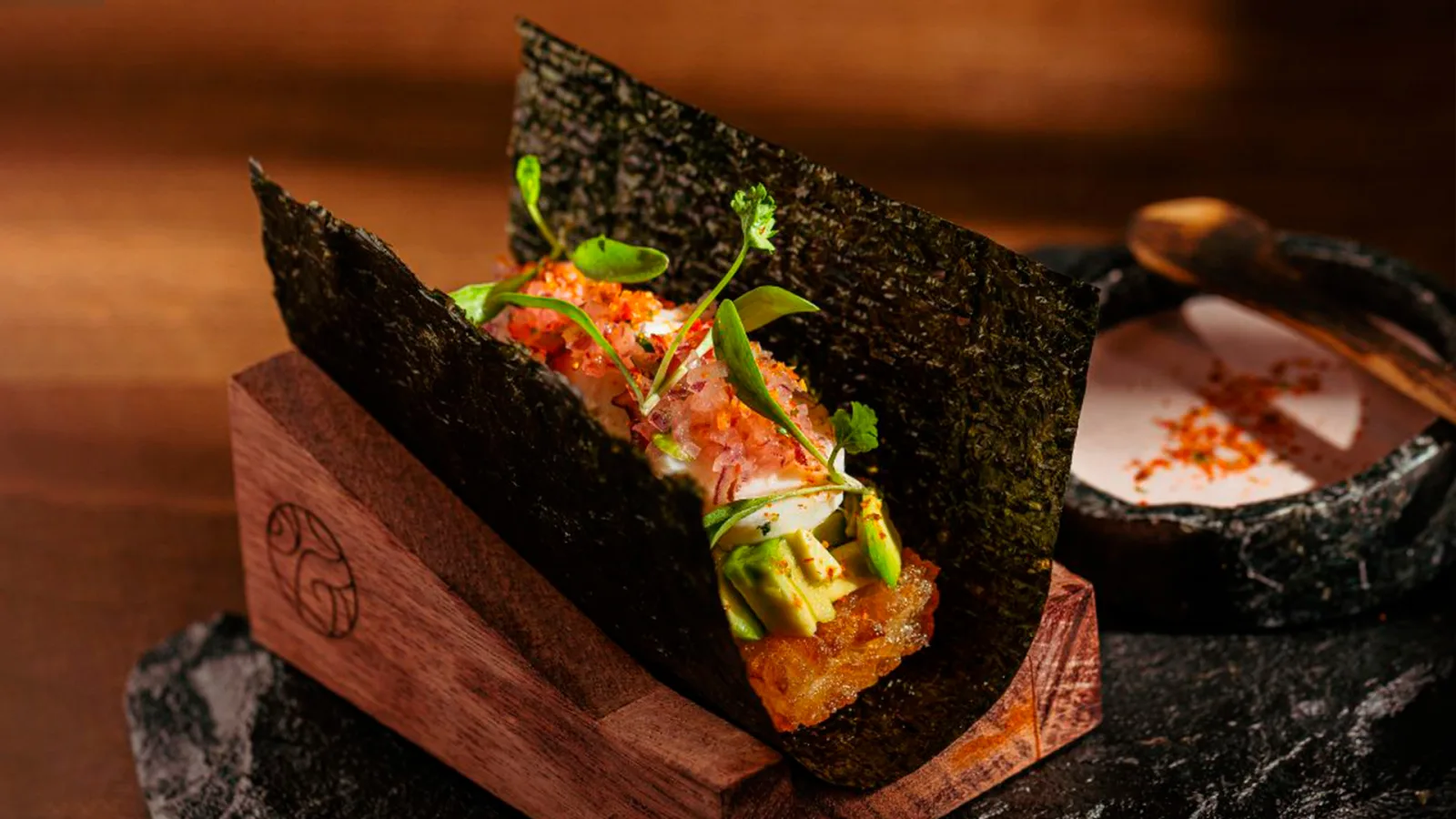 A temaki at Osaka, nori, fish and fresh herbs on a wooden stand